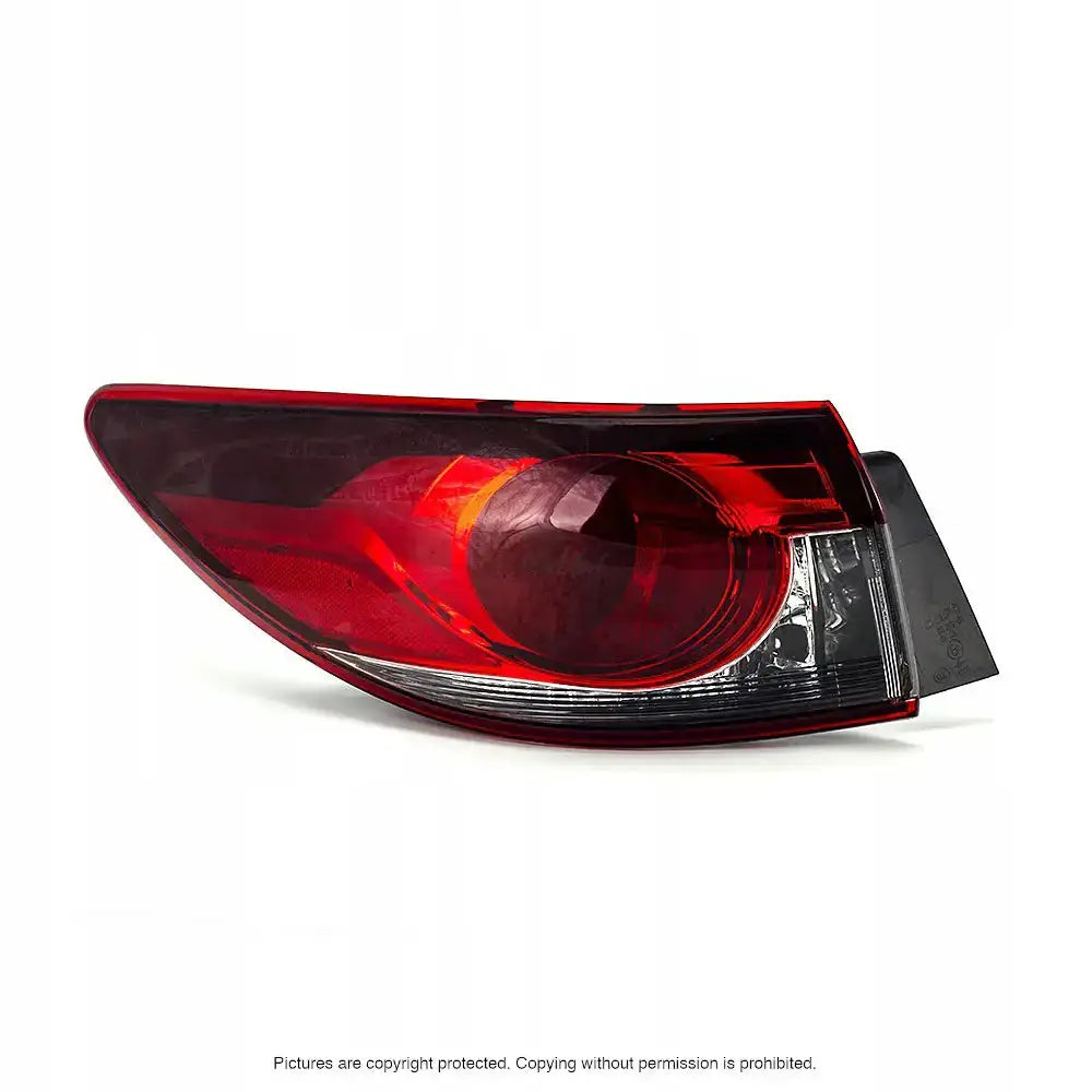 Baklykt Mazda 6 12-15 med rød og klar plast, synlig fra skrå sidevinkel mot hvit bakgrunn.