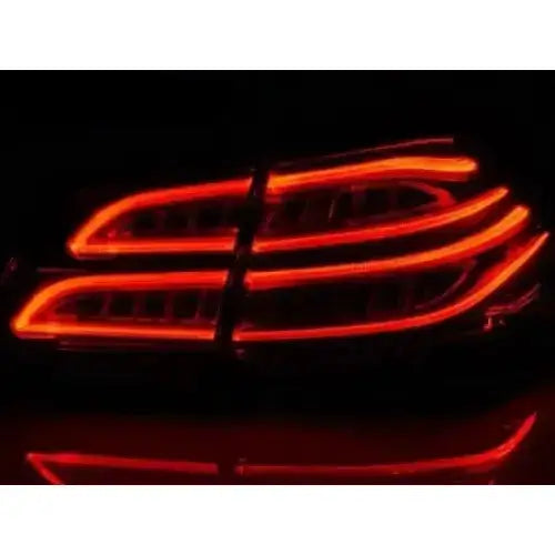 Baklykt Mercedes M-KLASA W166 LED med røde, bølgete lysmønstre sett rett bakfra i mørket.