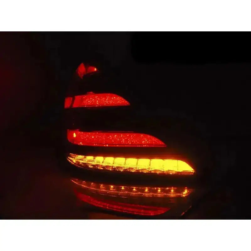Baklamper Mercedes S-Klasse W222 med røde og oransje LED-striper, sett skrått i mørket.