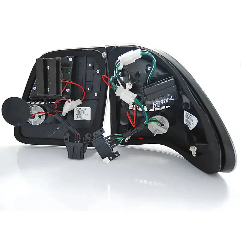 Baklys Mercedes W210 bakside med synlige ledninger, koblinger og elektroniske komponenter.