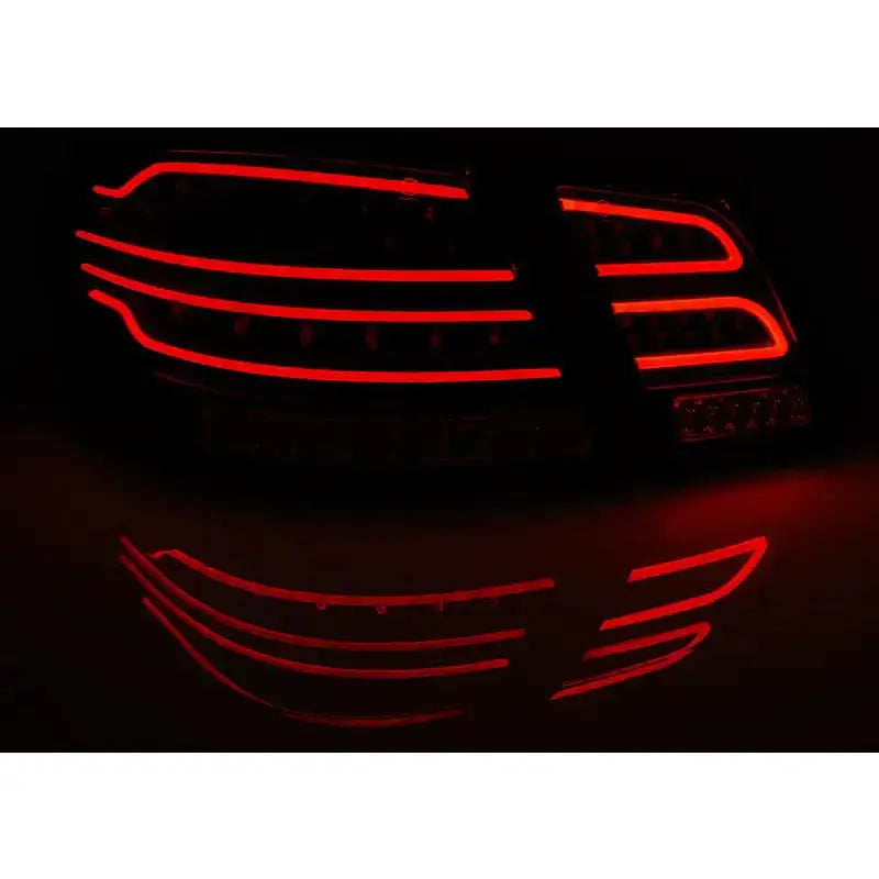 Baklys Mercedes W212 E-Klasse LED med røde horisontale striper og refleksjon på mørkt underlag.