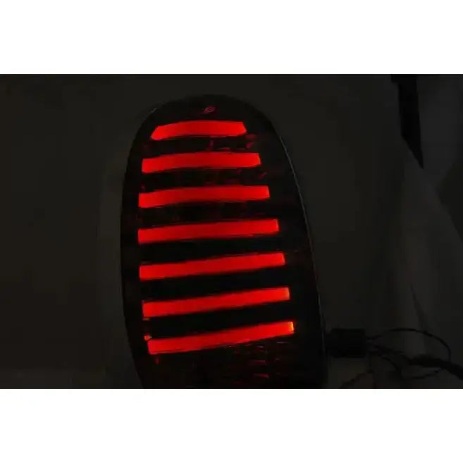 Baklys Mini R60 Countryman 10-14 med røde LED-striper, sett forfra i mørkt miljø.