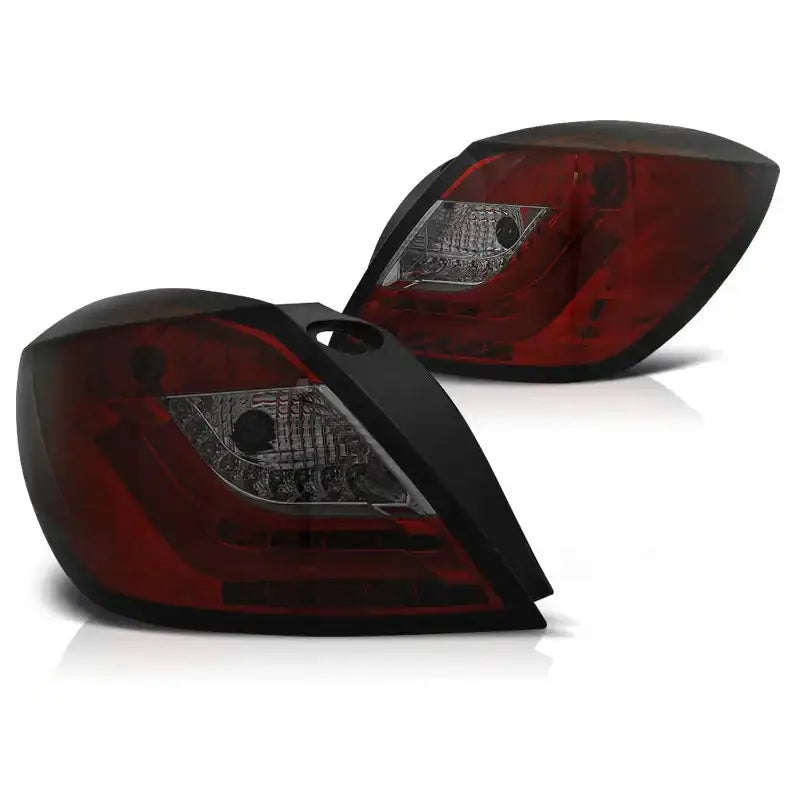 Baklykt Opel Astra H 3D GTC Red Smoke LED, to enheter sett fra skrå vinkel mot hvit bakgrunn.