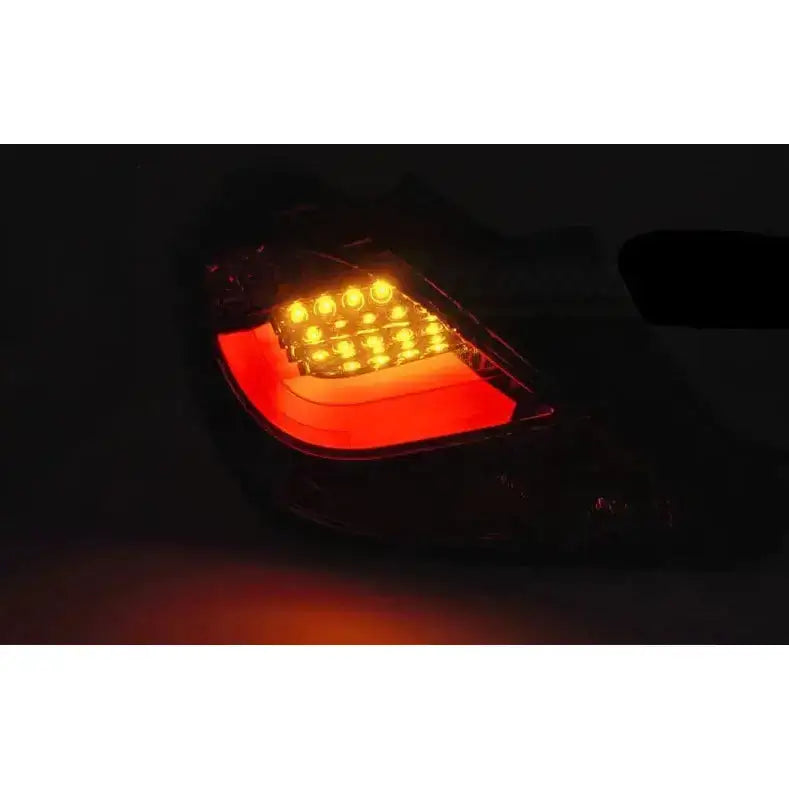 Baklys Opel Corsa D 3D Black Led Bar vist bakfra i mørket med opplyste gule og røde seksjoner.