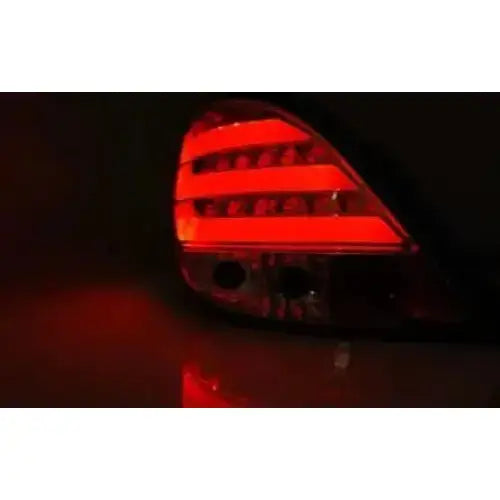 Baklys Peugeot 207 Chrome Led Bar med sterke røde horisontale linjer sett skrått bakfra i mørket.