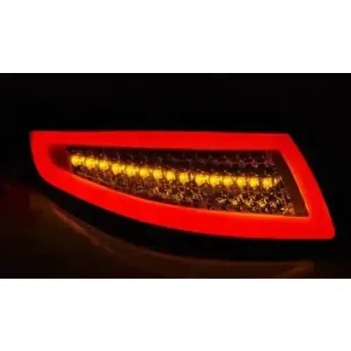 Baklys Porsche 911 997 med rød LED-ramme og gule dioder, avlangt design, skrå vinkel i mørket.