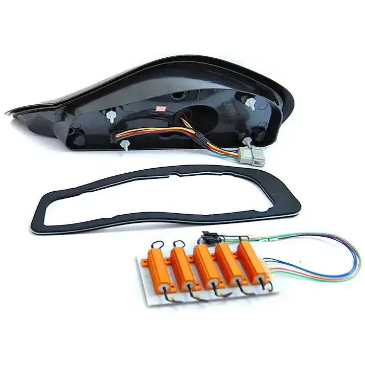 Baklys Porsche Boxster 986 svart deksel med tilkoblingskabler, gummipakning og kretskort med ledninger.