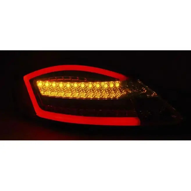 Baklamper Porsche Boxster 987 05-08 Black SEQ LED med rød LED-kant og oransje lysrekke i mørkt miljø.
