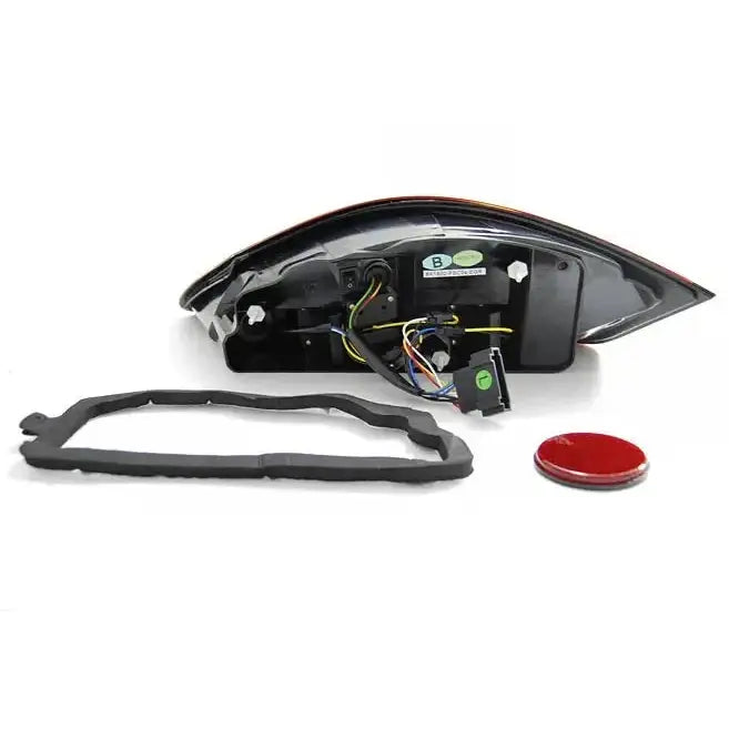 Baklykter Porsche Boxster 987 med ledninger, kontakter, svart gummipakning og rød reflektor.