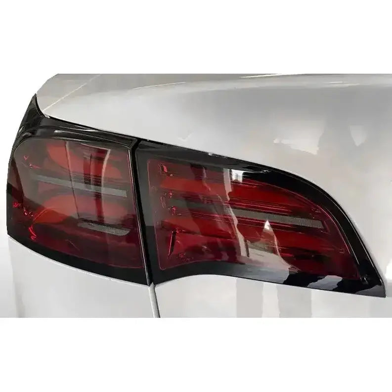 Baklykt Tesla Model 3 Red Smoke med røde og mørke detaljer på hvit bil sett fra skrå bakside.