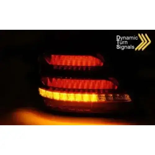 Baklys Red White Led Bar for Mercedes W203 med oransje dynamiske blinklys, sett bakfra i mørket.