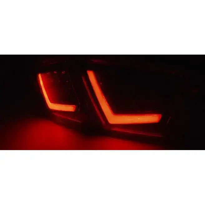 Baklys Seat Leon 03.09-13 LED med V-formet design, lyser rødt i mørket, sett skrått bakfra.