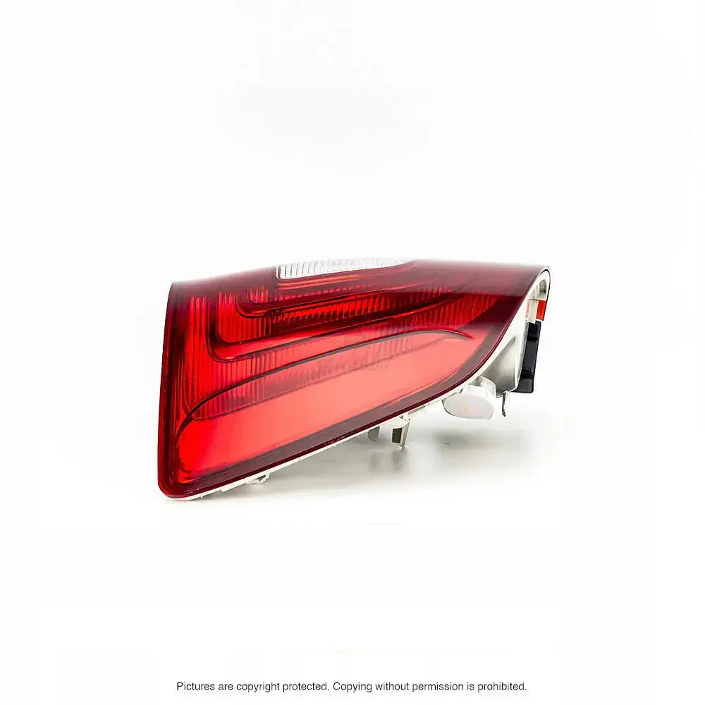 Baklykt Skoda Superb 08-13 med rødt glass og klart felt, sett skrått bakfra mot hvit bakgrunn.