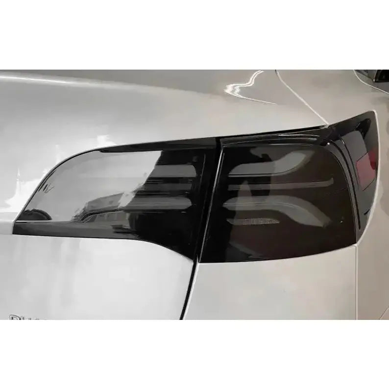 Baklykt Smoke Black for Tesla Model 3 med sotet glass sett skrått bakfra på hvit bil.