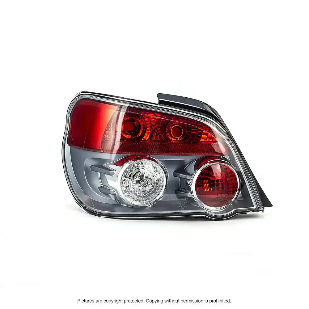 Baklykt Subaru Impreza II 01-07 med rød og klar linse, reflektorer og pærer synlige, sett skrått forfra.