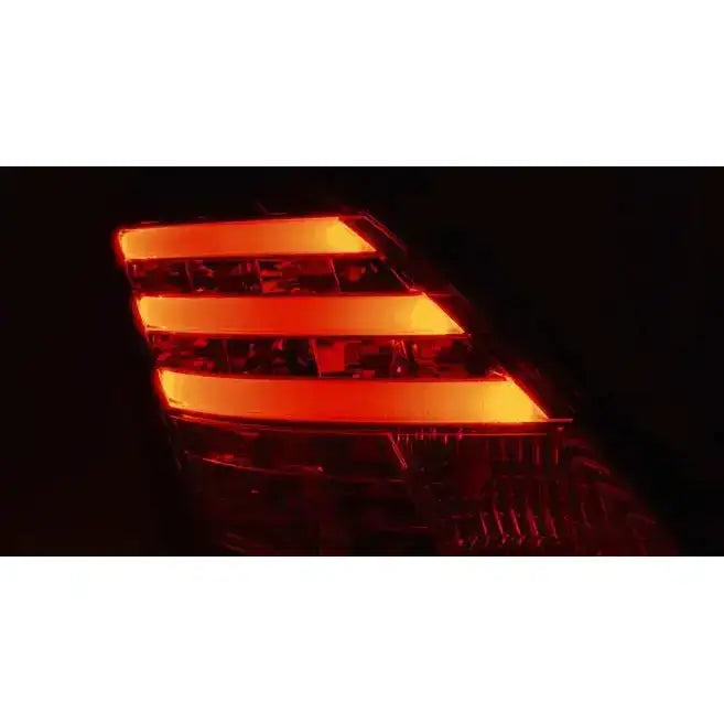 Baklys Suzuki Swift IV 10- med tre røde LED-striper, sett fra skrå vinkel i mørkt miljø.