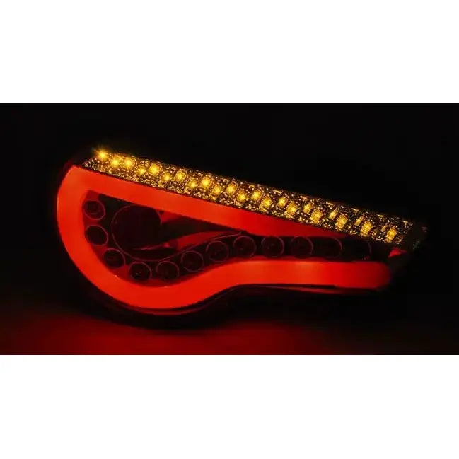 Baklykter Toyota GT86 LED Bar Smoke med rødt og gult lys, buet design, avbildet i mørket.