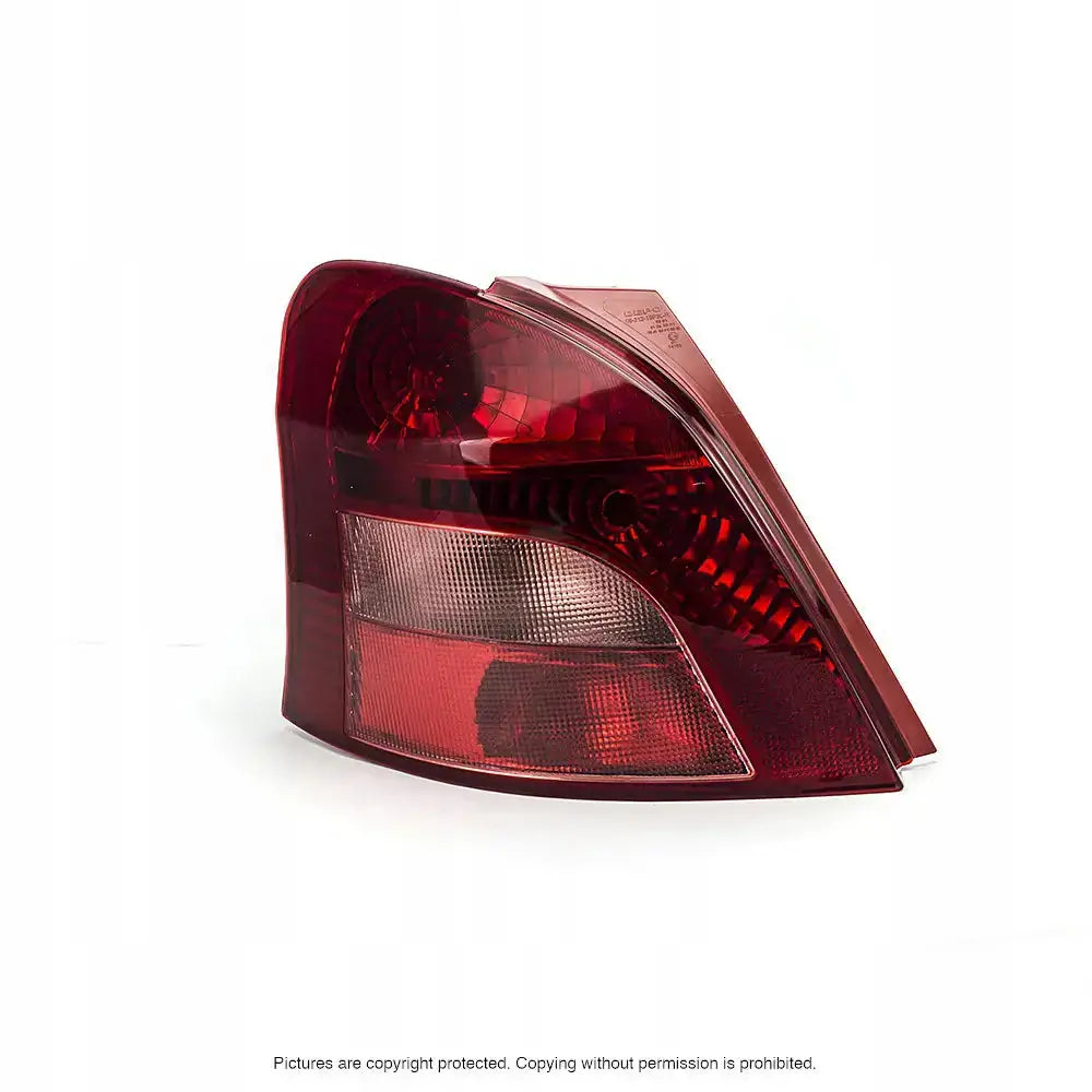 Baklykt Toyota Yaris 05-11 med rød og klar plast, sett fra skrå bakside mot hvit bakgrunn.