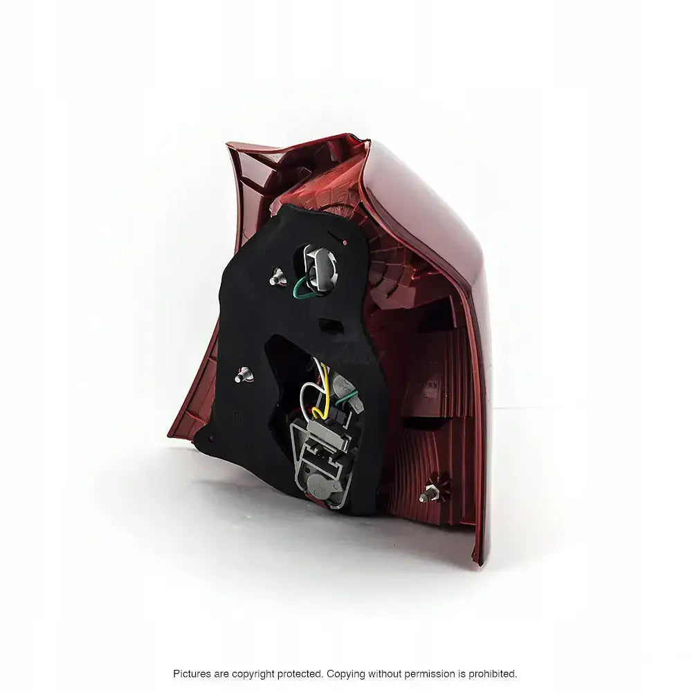 Baklamper Toyota Yaris 05-11 bakside med synlige ledninger og festeskruer mot hvit bakgrunn.