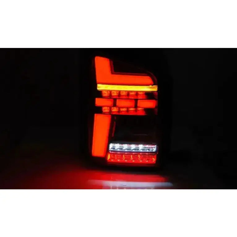 Baklykter Volkswagen T5 Black Smoke Full Led tent i mørket med røde, oransje og hvite lysfelt.