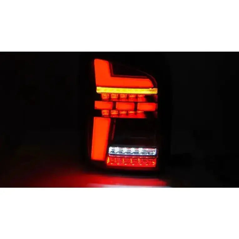 Baklykter Volkswagen T5 04.03-09 Smoke Full Led med geometriske LED-lys mot mørk bakgrunn.