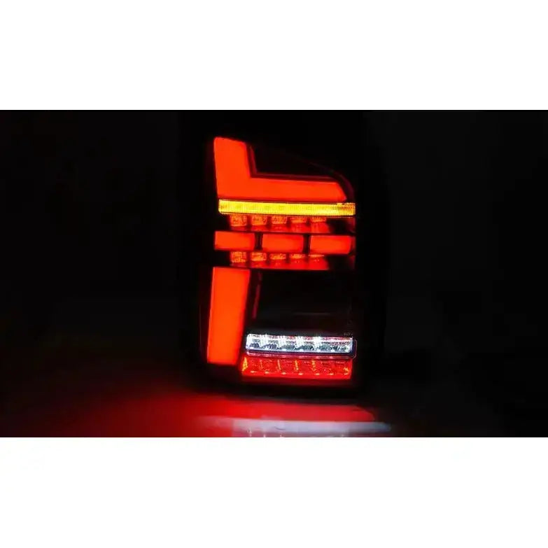 Baklykter Volkswagen T6.1 LED med røde og oransje lysfelt sett forfra i mørkt miljø.
