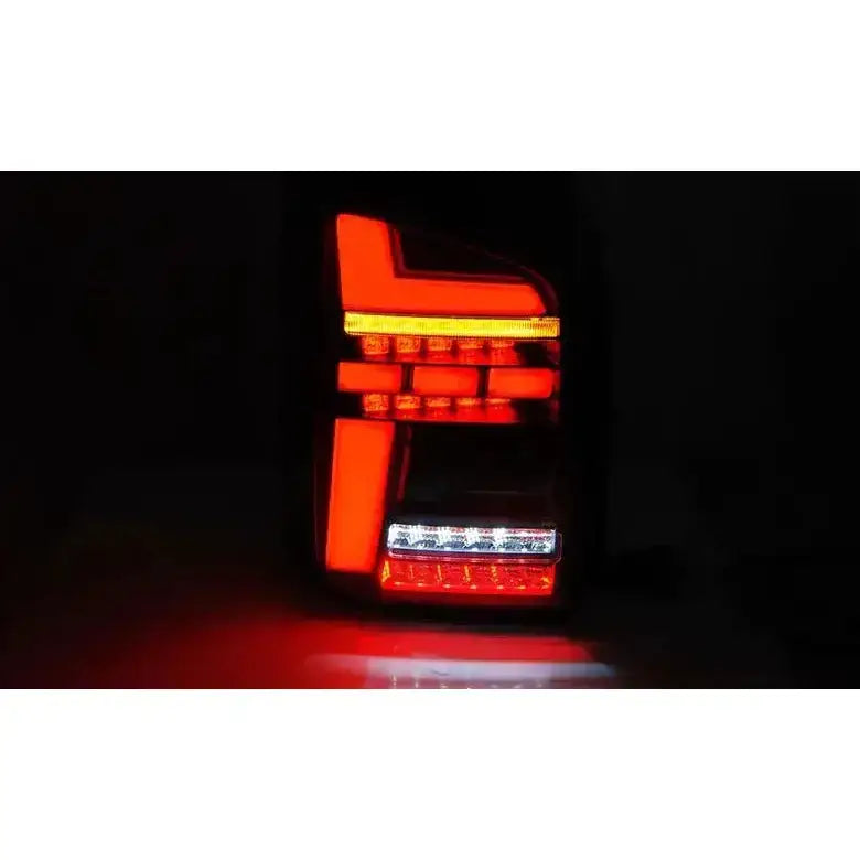 Baklykter Volkswagen T6.1 LED baklykt med rødt, hvitt og oransje lysmønster, fotografert forfra i mørket.