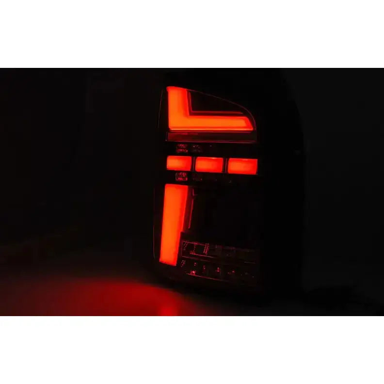 Baklykt Volkswagen T6 15-19 LED Black med røde lys i mønstrede segmenter, sett fra skrå vinkel.