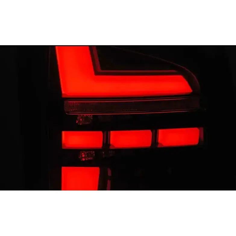 Baklys Volkswagen T6 15-19 LED med rød L-formet lyssignatur, sett fra skrå vinkel i mørket.