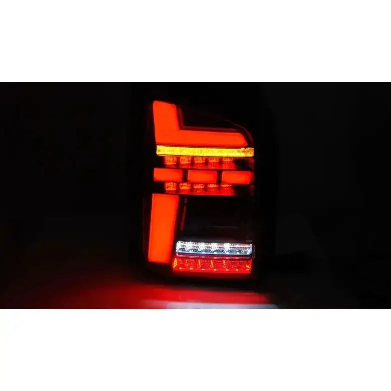 Baklykter Volkswagen T6 15-19 LED Red Smoke sett forfra med tydelig rødt og hvitt lys i mørkt miljø.