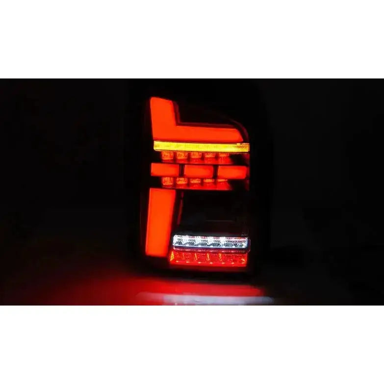 Baklykter Volkswagen T6 15-19 LED Red Smoke sett forfra med rød, hvit og oransje belysning.