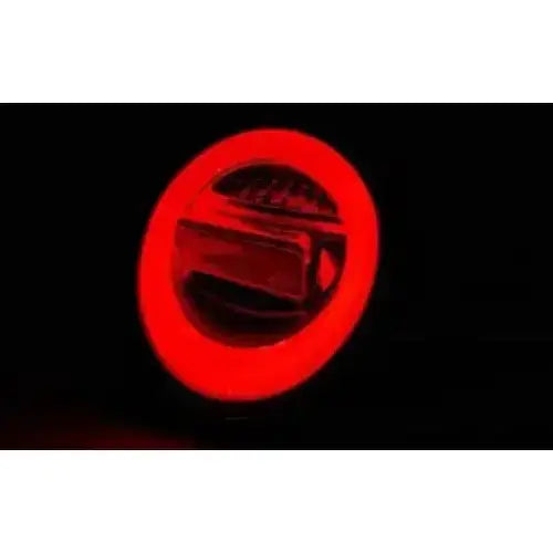 Baklykt Vw Beetle LED med rød kant og blank metallisk midtdel, sett forfra i mørket.