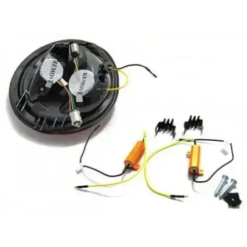 Baklamper Vw Beetle komponenter med ledninger, sølvfargede sylindere og oransje motstander sett ovenfra.