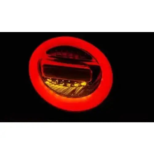 Baklys Vw Beetle 10.98-05 med rød lysring og gule LED-detaljer sett forfra mot svart bakgrunn.