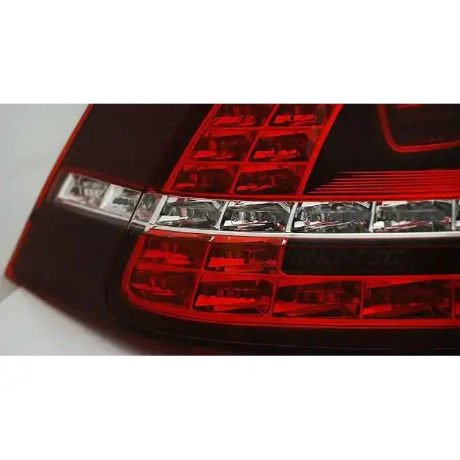 Baklamper Vw Golf 7 LED baklys i rødt og klart plast med sølvdetaljer, nærbilde fra skrå vinkel.