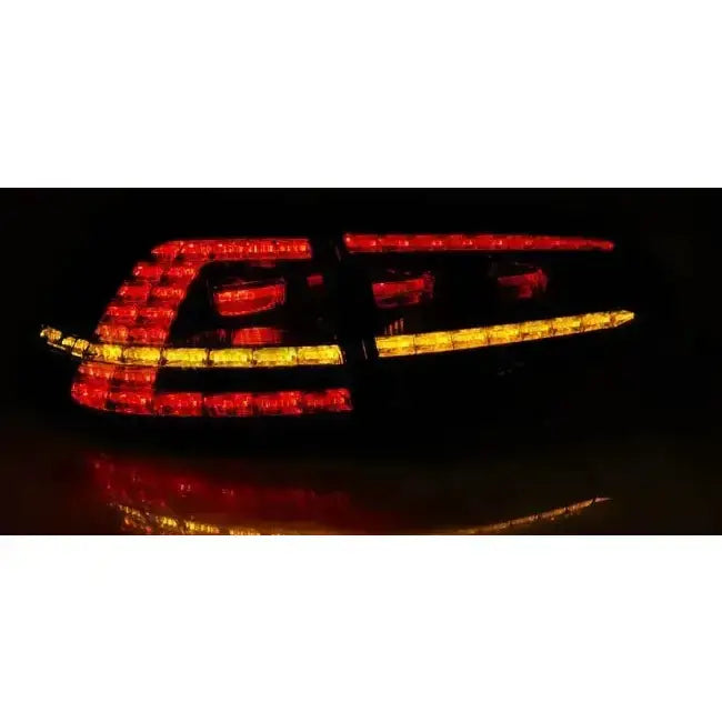 Baklykter VW Golf 7 13-17 LED GTI Look sett bakfra med rødt og oransje lys i mørkt miljø.