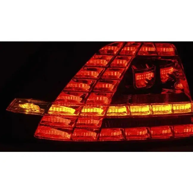 Baklamper Vw Golf 7 Black LED GTI Look med røde og gule lys vist i mørket fra skrå vinkel.