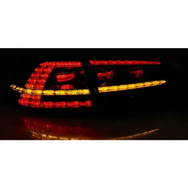 Baklykter Vw Golf 7 LED sett forfra i mørket med røde og gule lyslinjer.