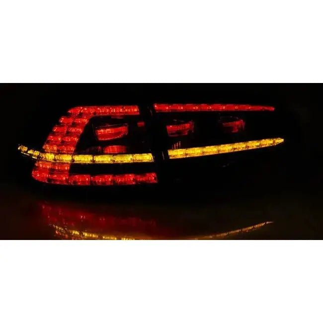 Baklykter Vw Golf 7 LED GTI Look med røde og gule striper, sett skrått i mørket.