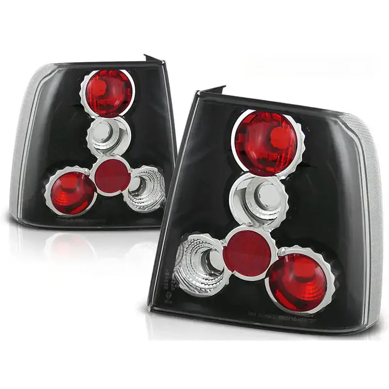 Baklykter Vw Passat B5 sedan i sort og krom med runde røde linser, sett skrått forfra.