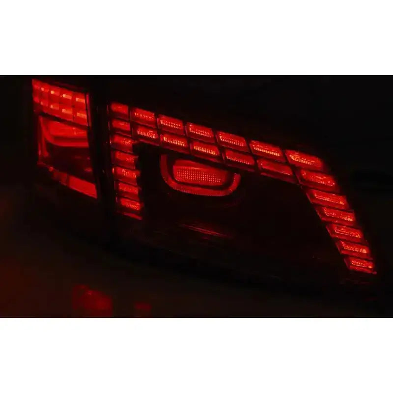 Baklys Vw Passat B7 Variant LED med røde segmenterte felt, fotografert skrått bakfra i mørket.
