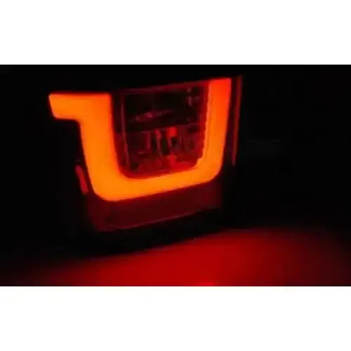 Baklykt Vw T4 90-03.03 Red White LED Bar lyser rødt i U-form, fotografert forfra mot mørk bakgrunn.