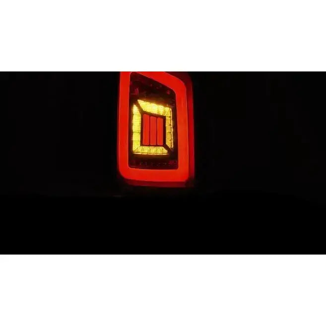 Baklys Vw T5 LED med rød og gul belysning, nærbilde av rektangulære elementer mot mørk bakgrunn.