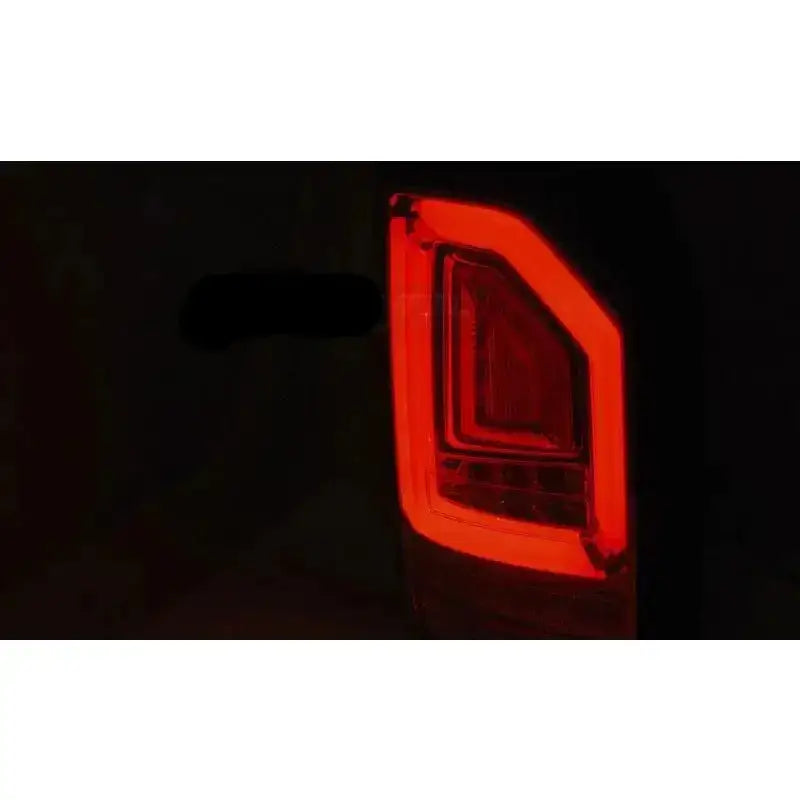 Baklamper Vw T6 2015 med rødt LED-lys, vist fra skrå vinkel mot mørk bakgrunn.