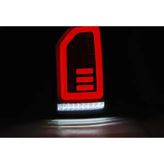 Baklys Vw T6 2015- med rød LED og hvit lysstripe, sett forfra mot svart bakgrunn.