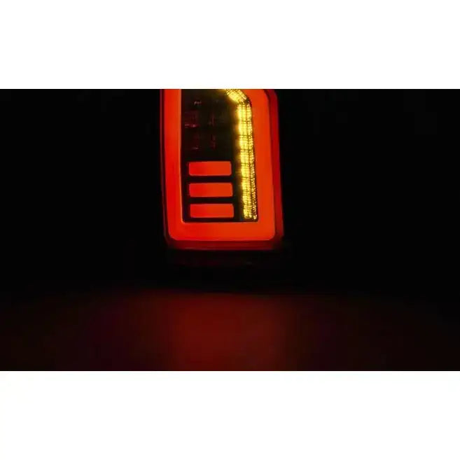 Baklamper Vw T6 2015- i smoke black white LED, nærbilde med gul LED-stripe i mørkt miljø.