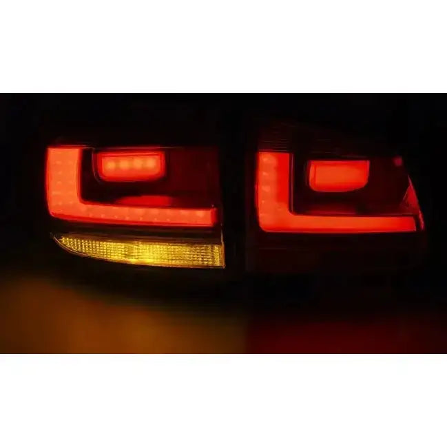 Baklys Vw Tiguan 07-07.11 med rødt LED-lys og gult blinklys, moderne kantet design, vist i mørket.