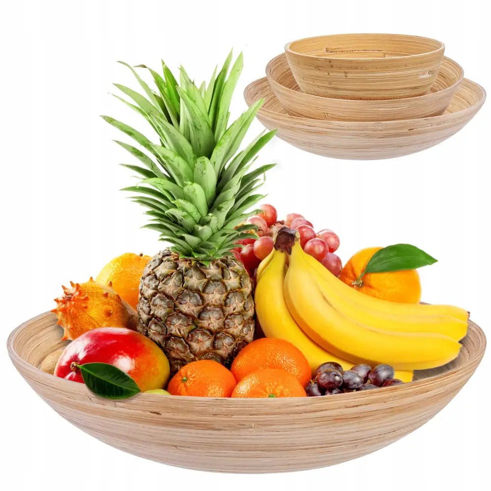 Bambus skålsett stablet med frisk ananas, banan, appelsin og druer på hvit bakgrunn.