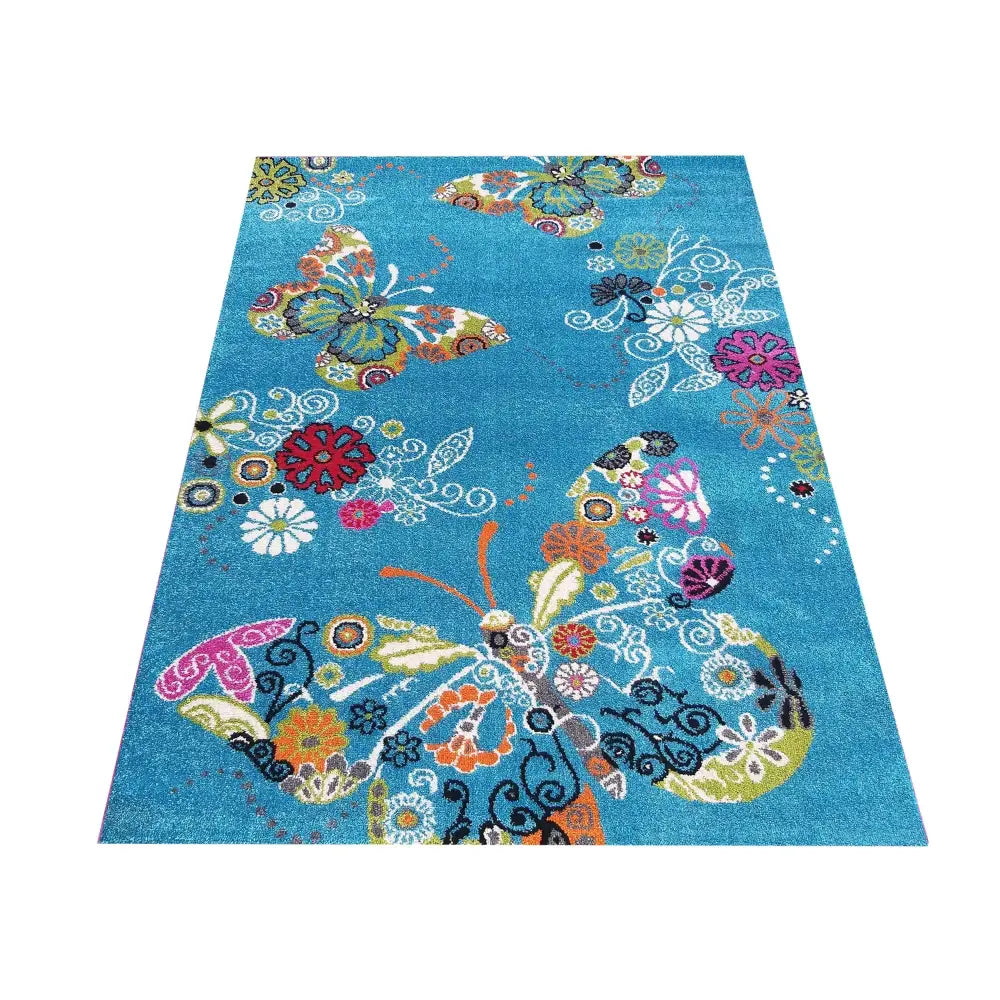 Bella 114 blått teppe 200 x 290 cm, sett ovenfra med fargerike sommerfugler og blomster på lys bakgrunn.