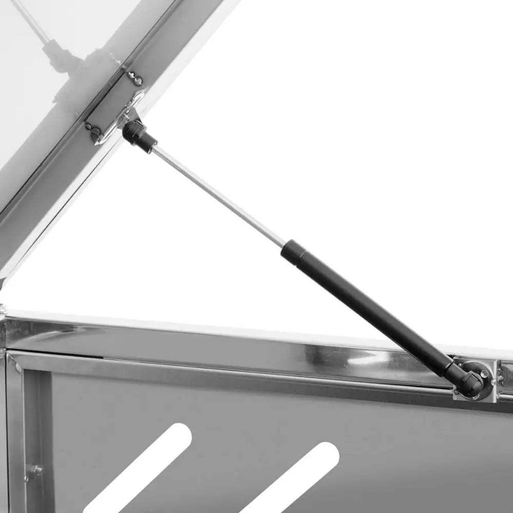 Gassdemper for beskyttelsesdeksel, nærbilde av metallkomponent montert på sølvfarget lokk.